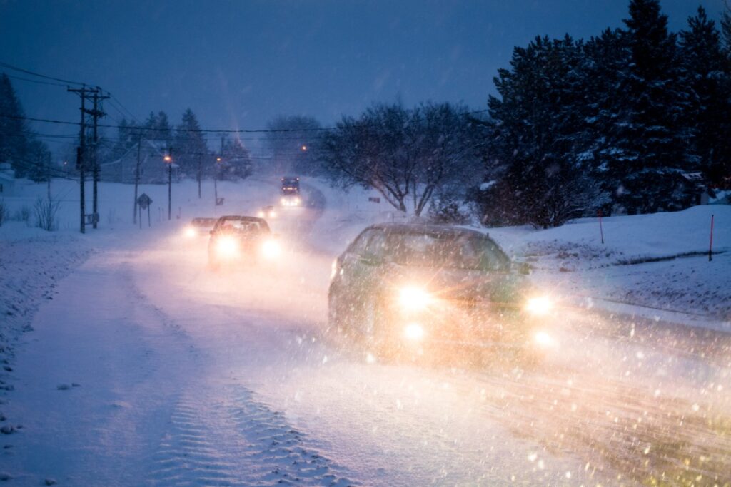 Car driving safely on snowy winter road with improved tire traction